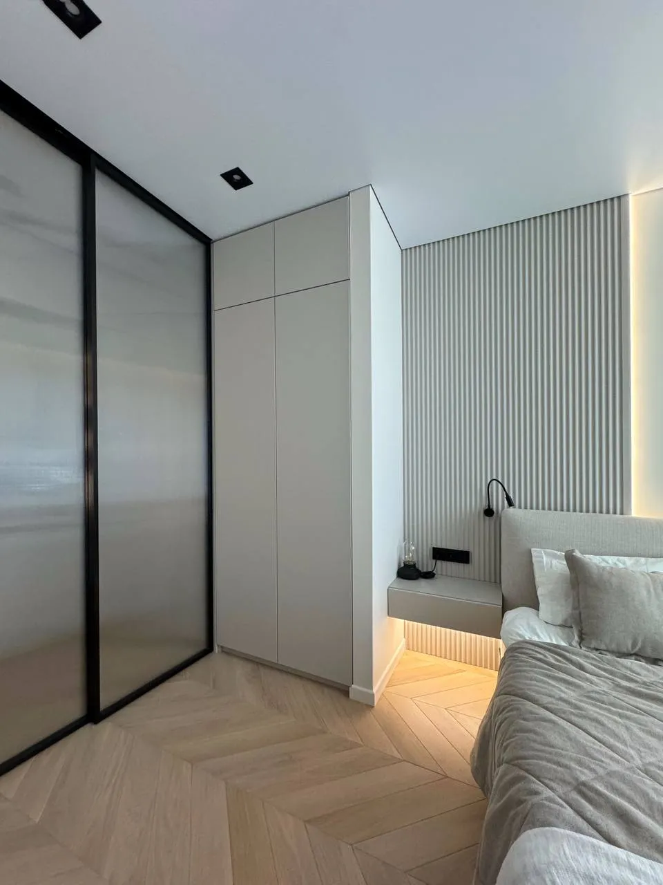 Раздвижная матовая стеклянная перегородка и безпрофильные двери для встроенного шкафа купе от Gintereo в интерьере спальни
