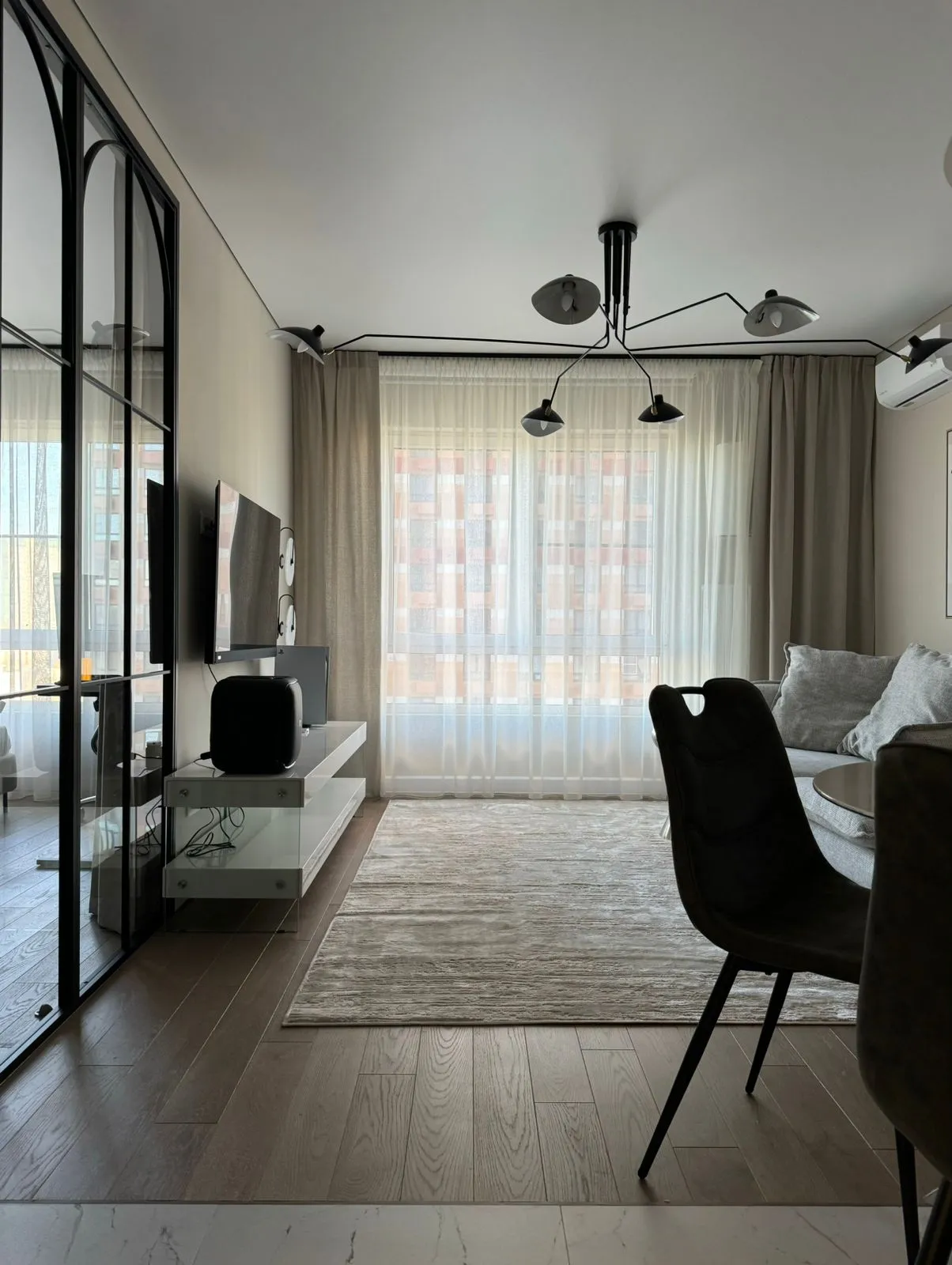 Фото интерьера гостиной, которая зонирована от спальни статичной межкомнатной перегородкой в стиле лофт от Gintereo