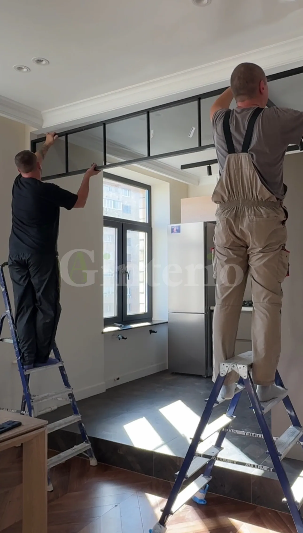 Специалисты Gintereo устанавливают межкомнатную стеклянную распашную перегородку для зонирования кухни на объекте