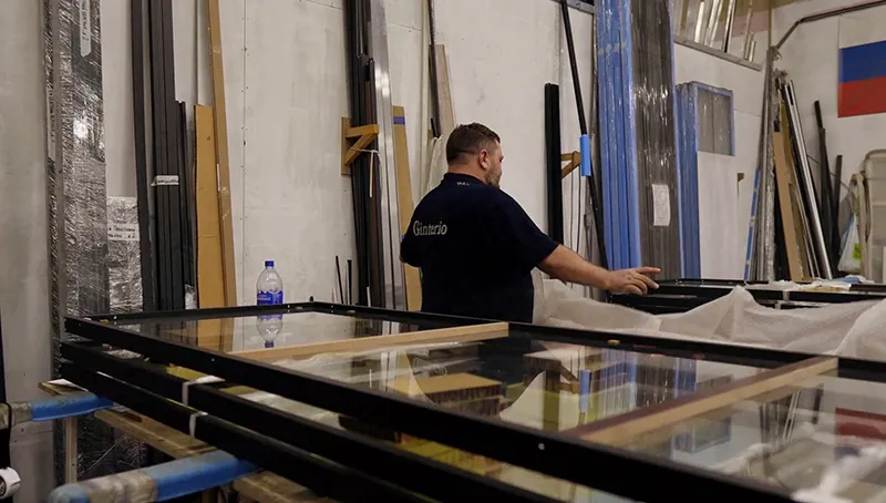 Специалист Gintereo работает на производстве межкомнатных перегородок из алюминия в стиле лофт и дверей