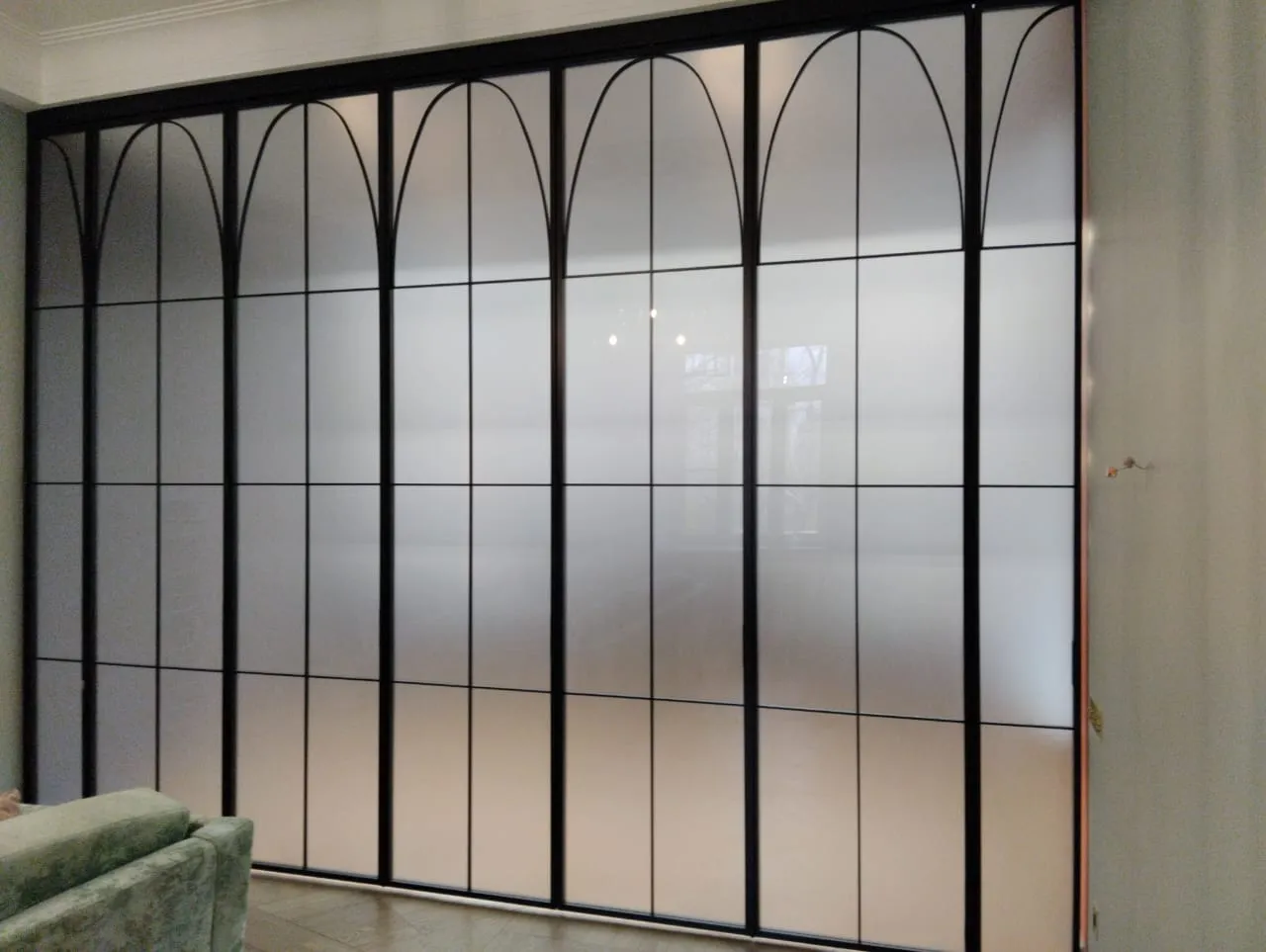 Статичная межкомнатная перегородка из матового стекла с декоративными элементами и черным алюминиевым профилем