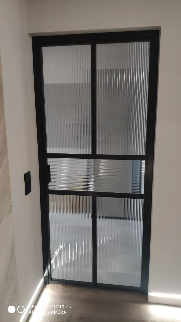 Стеклянная межкомнатная дверь с черным алюминиевым профилем Gintereo. Купить дверь из рифленого стекла в Москве, СПБ