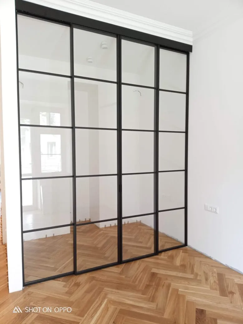 Раздвижная межкомнатная перегородка из прозрачного стекла серии SLIDE от Gintereo для зонирования помещений и комнат квартиры