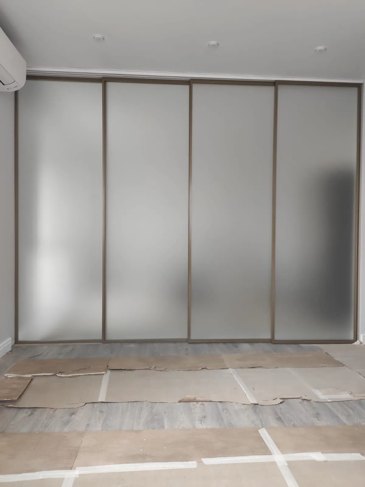 Раздвижная межкомнатная перегородка из матового стекла с бронзовым профилем от Gintereo. Купить стеклянную перегородку в МСК