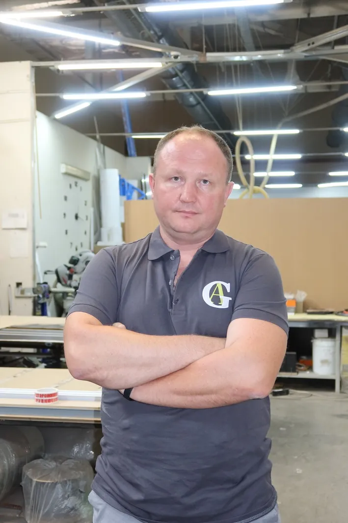 Сотрудник производителя алюминиевых межкомнатных перегородок и дверей Gintereo на производстве в Москве