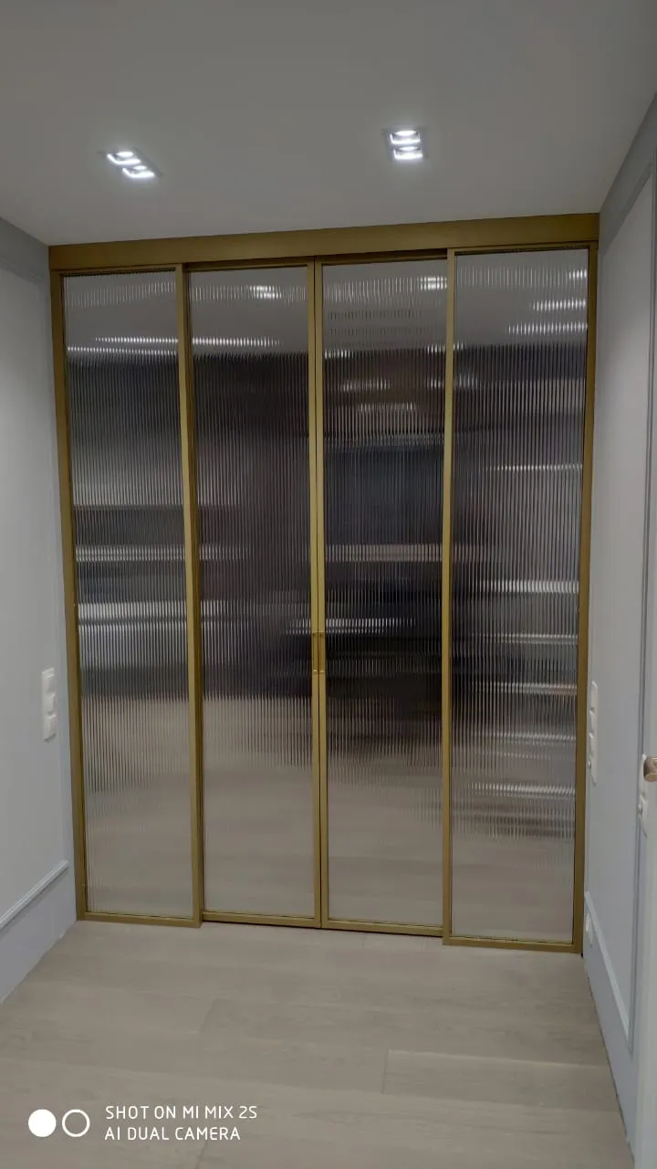 Межкомнатная перегородка из рифленого стекла и золотого алюминиевого профиля Gintereo. Купить стеклянную перегородку на заказ