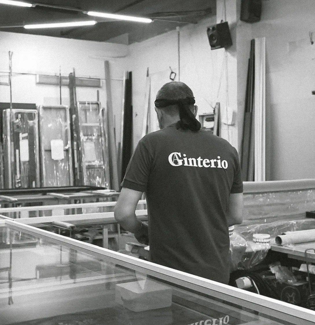 Сотрудник компании по производству алюминиевых межкомнатных перегородок и дверей Gintereo работает на предприятии в Москве