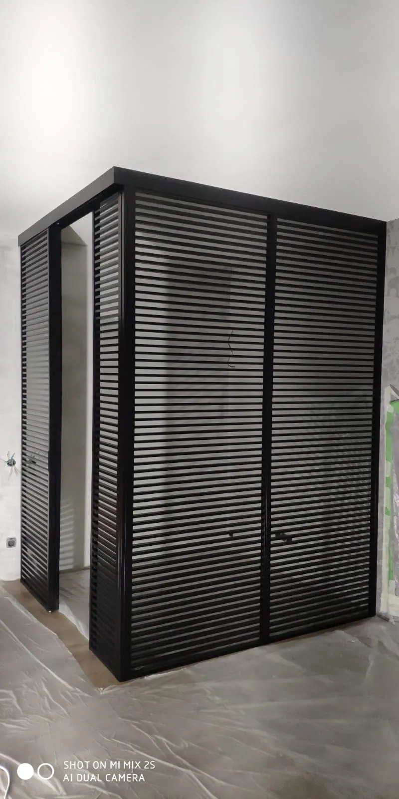 Зона будущего кабинета, отделенная с помощью реечных перегородок из черного алюминиевого профиля. Проект Gintereo в Москве