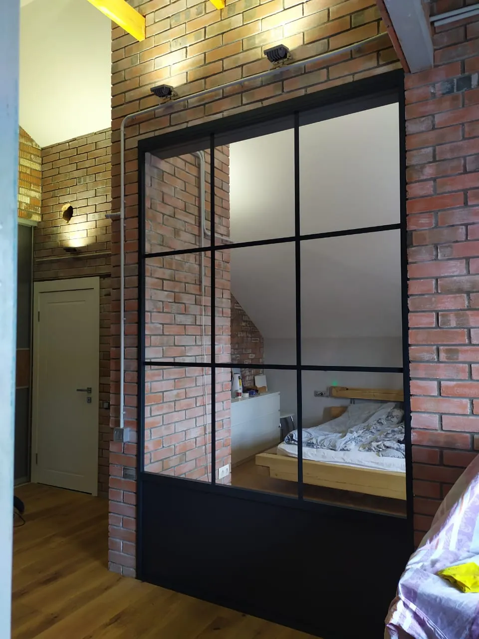 Межкомнатная черная перегородка в интерьере лофт-спальни. Купить стеклянные перегородки под заказ в Москве, СПБ