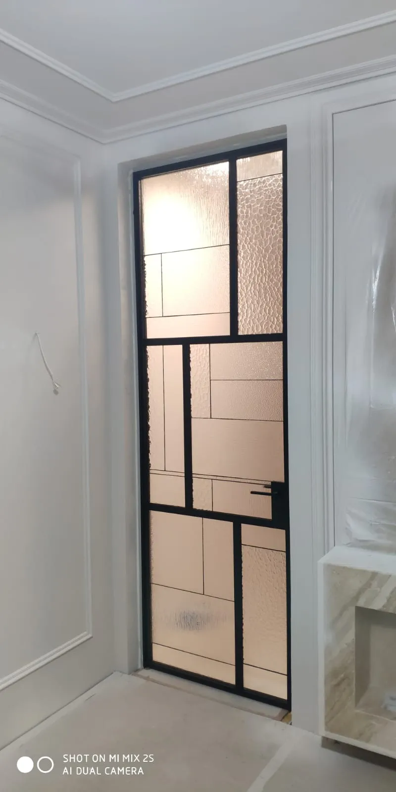 Межкомнатная дверь из декоративного рифленого стекла с черным профилем. Проект Gintereo. Заказать, купить стеклянную дверь