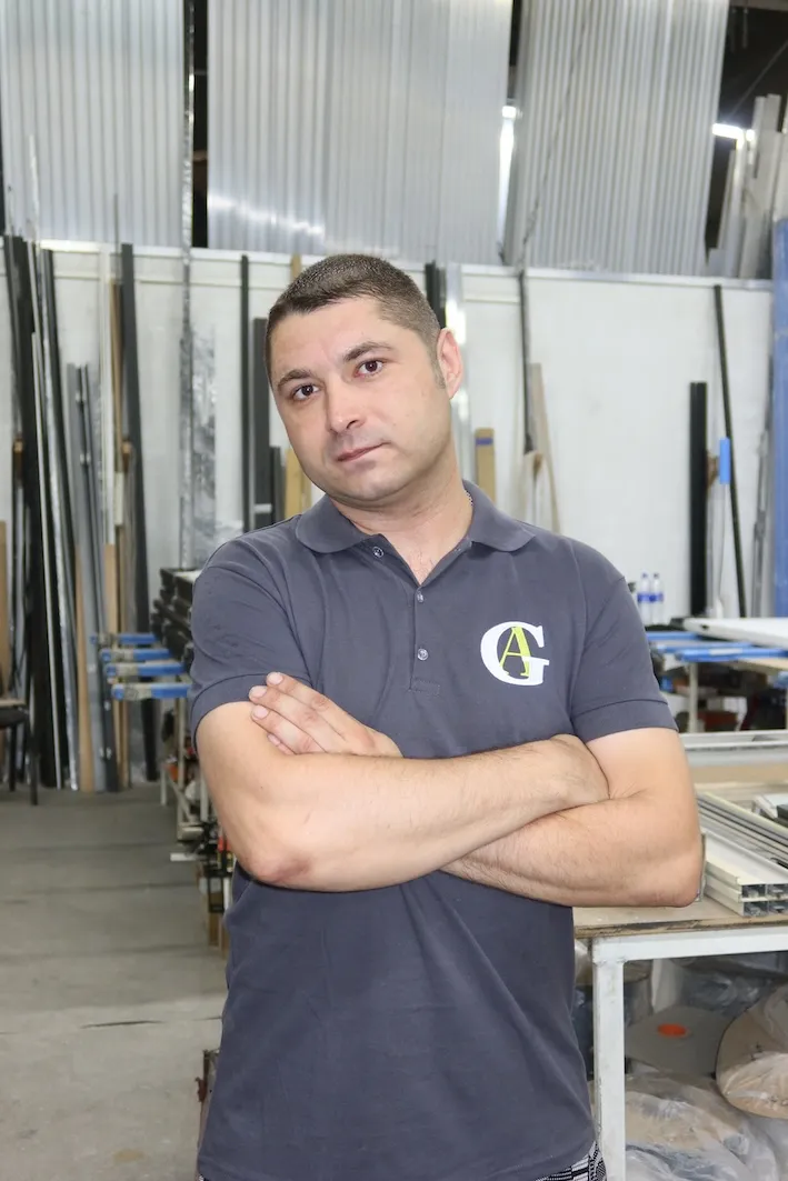 Фотопортрет специалиста Gintereo на производстве межкомнатных алюминиевых перегородок для зонирования из стекла в стиле лофт