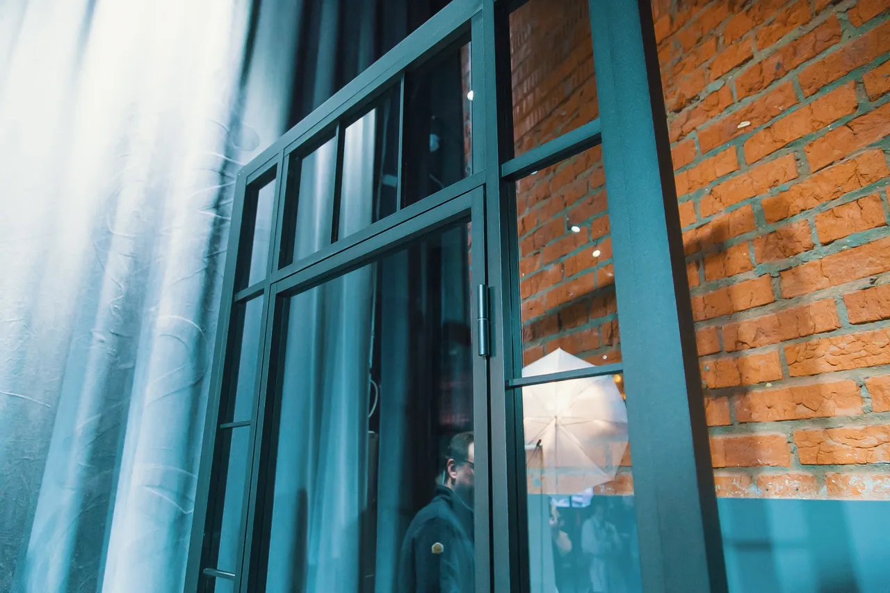 Образец статичной межкомнатной перегородки из прозрачного стекла с распашной дверью на выставке (шоуруме) Gintereo