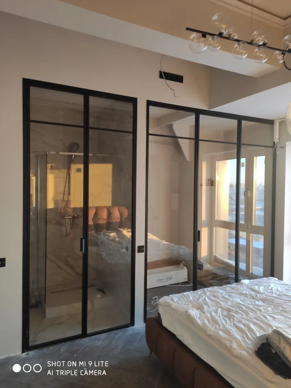 Двухстворчатые стеклянные прозрачные двери и раздвижная межкомнатная перегородка для зонирования Gintereo в интерьере спальни