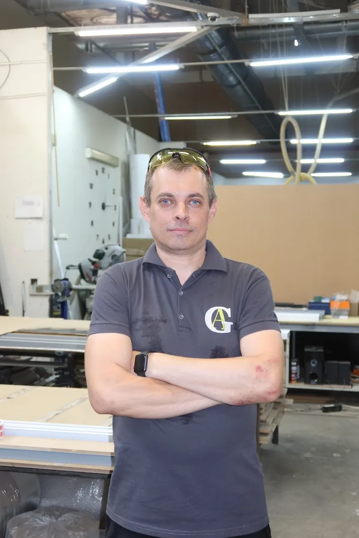 Фотопортрет мужчины в форме Gintereo на производстве межкомнатных алюминиевых лофт перегородок для зонирования из стекла