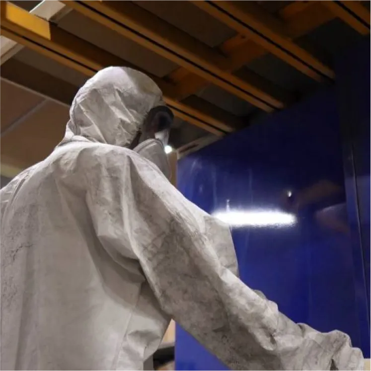 Специалист Gintereo в защитном костюме делает порошковую окраску межкомнатных перегорожок для зонирования в стиле лофт