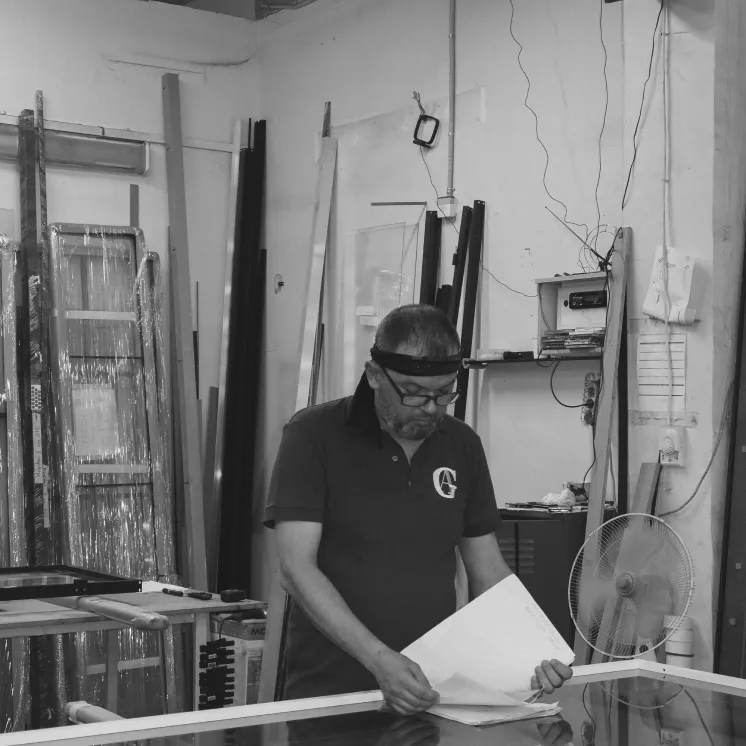 Трое мастеров Gintereo держат лист шпона для проектирования беспрофильных раздвижных дверей для встроенного шкафа-купе