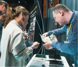 Специалист Gintereo делает расчет стоимости межкомнатных перегородок из алюминия в стиле лофт на выставке в Москве и СПБ